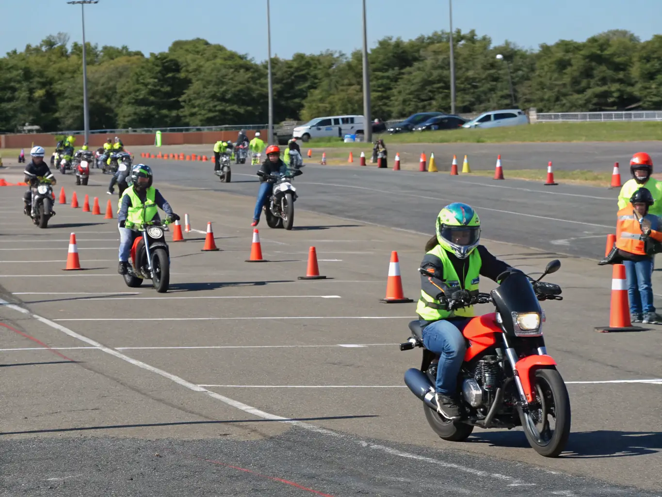 A group of motorcyclists participating in an advanced riding skills training session on a closed circuit, focusing on cornering techniques and safety protocols.