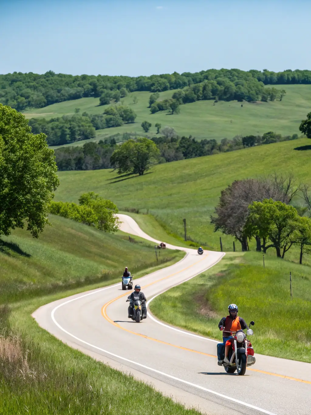 A dynamic photo of riders participating in a scenic motorcycle tour through countryside roads, showcasing the Motorcycle Sports and Tourism Activities offered by TRS ASS TEAM ROUDY SPORT.